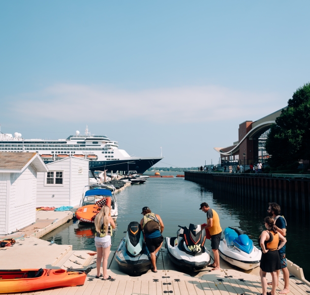 People enjoying water sports such as kayaking, paddleboarding, and boating in Charlottetown Harbour on a sunny summer day.
