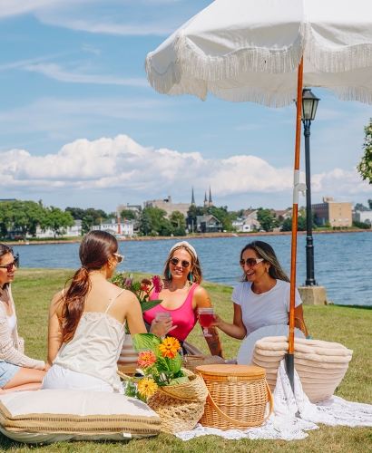 Group of friends enjoying a picnic in Victoria Park in Charlottetown, Prince Edward Island, on a sunny day near the waterfront.