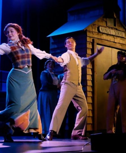 A live stage performance of Anne of Green Gables: The Musical featuring actors in period costumes performing in Charlottetown, Prince Edward Island.