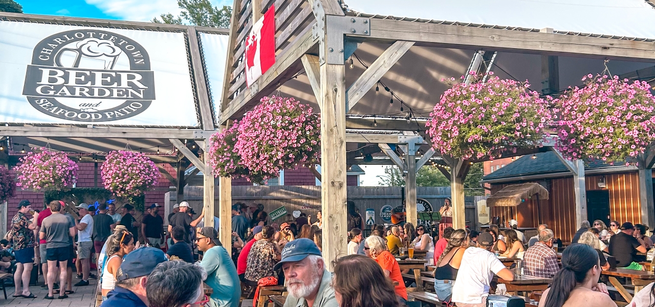 Guests enjoying drinks and food on the outdoor Beer Garden patio in downtown Charlottetown, Prince Edward Island.