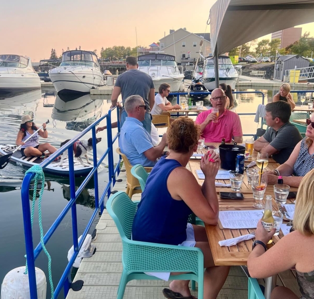 Guests enjoying food and drinks on the outdoor patio at The Grotto in downtown Charlottetown, Prince Edward Island.