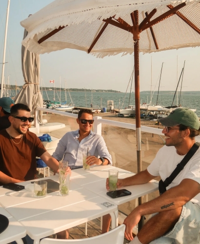 Guests seated on the outdoor waterfront patio at Salt & Sol in Charlottetown, Prince Edward Island, enjoying harbour views.