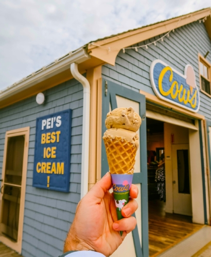 A waffle cone topped with ice cream from COWS, enjoyed outdoors in Charlottetown, Prince Edward Island on a summer day.
