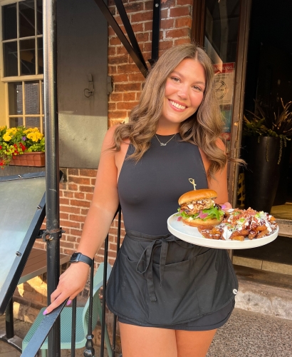 Server delivering food and drinks at Brickhouse Kitchen & Bar's outdoor patio in downtown Charlottetown, Prince Edward Island.