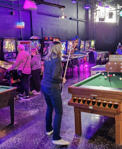 People playing pinball machines in an arcade in Charlottetown PEI, a fun indoor rainy day activity