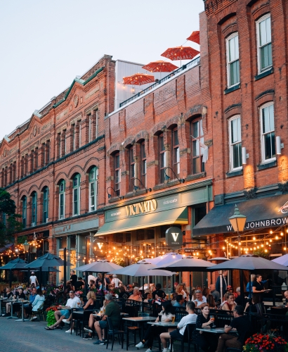 Outdoor patios along Victoria Row in downtown Charlottetown, Prince Edward Island, with restaurants, seating, and a vibrant street scene.
