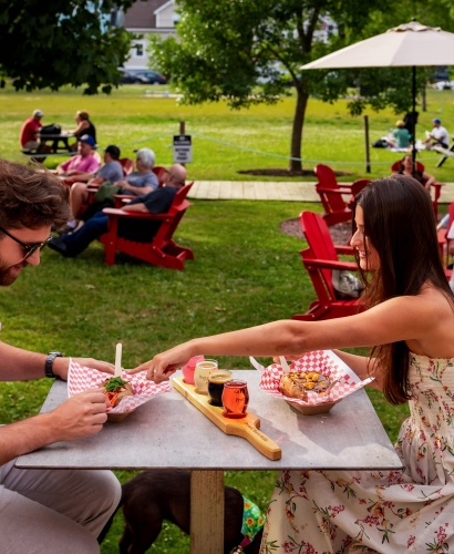 Guests enjoying food and drinks on the outdoor patio at Founders Food Hall & Market in downtown Charlottetown, Prince Edward Island.